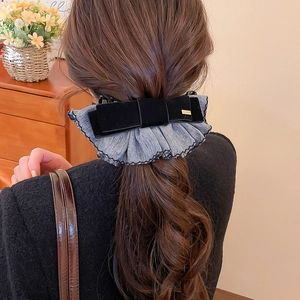 Gros plan détaillé d'une barrette en velours à deux couches sur cheveux longs ondulés