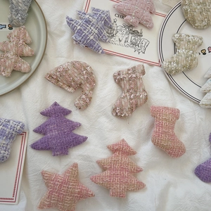 Macro detail of tweed Christmas tree and star ornaments with shimmering textures