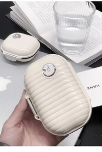 Mini cream suitcase pill box with vertical stripes and metallic clasp for small items