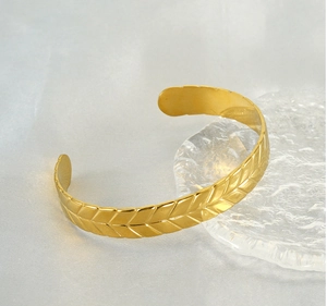 Detailed macro view of the gold wheat ear engraving on this stainless steel cuff bracelet