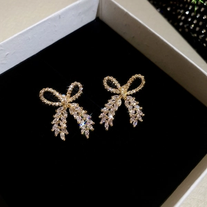 Close-up of sparkling zircon bow earrings placed in a black velvet jewelry gift box