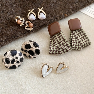 Detail of assorted geometric earrings with leopard print, houndstooth, and pearl accents