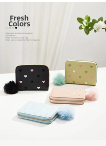 Detail of short leather wallets with heart embroidery and fluffy fur ball pendants
