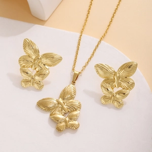 Detail of golden butterfly necklace and earrings set with delicate textures on stone