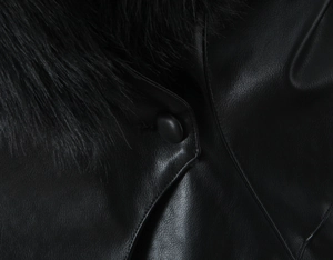 Gros plan sur la texture d'une veste en cuir noir avec col en fausse fourrure et bouton