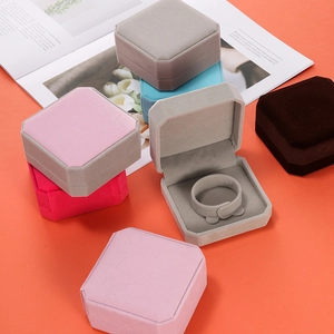 Octagonal velvet jewelry box for bracelets shown in multiple colors on a stylish magazine