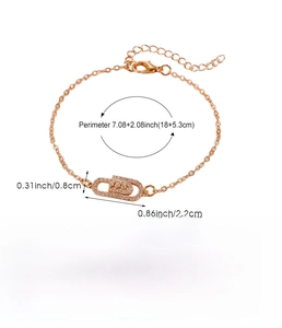 Detailed view of a gold safety pin bracelet with zircon inlay and copper base specifications