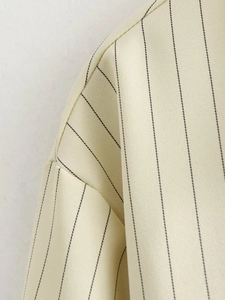 Close-up of beige vertical striped fabric texture and precision seam stitching details