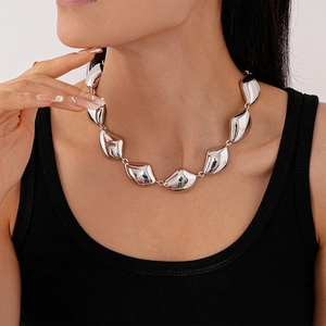 Collana geometrica d'argento audace con grani irregolari indossata su un top nero