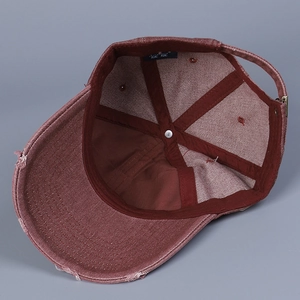 Detail view of washed denim cap interior with adjustable metal buckle and distressed edges