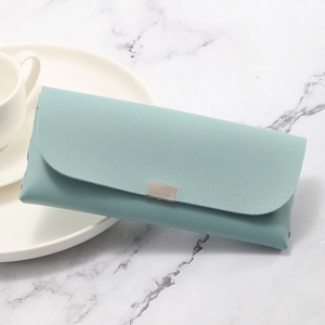 Minimalist Morandi blue faux leather glasses case with metal buckle on marble background