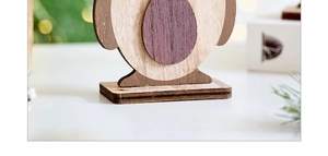 Macro detail of a layered wooden penguin figurine with natural wood grain and base