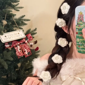 Elegant knitted flower hair clips with pearls on woman's side-swept hair in festive scene