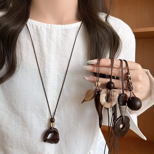 Bohemian style long necklace with irregular resin pendants and wooden beads shown on a model