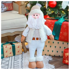 Dettaglio di Babbo Natale in peluche lavorato a maglia bianca vicino all'albero