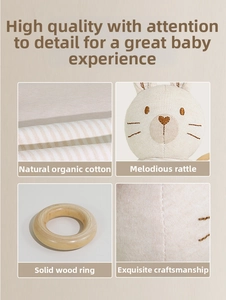 Detail of organic cotton baby rattle with wooden ring, embroidery and fine stitching
