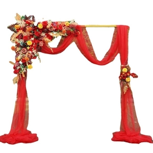 Detail of red wedding arch fabric with artificial autumn maple leaves and floral clusters