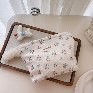 Detailed macro view of cotton makeup bag with blue berry print and simple wish label