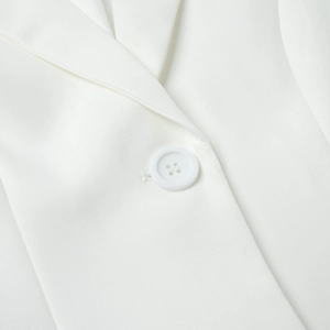 Close-up of white lace blazer featuring a single-breasted button and premium woven texture