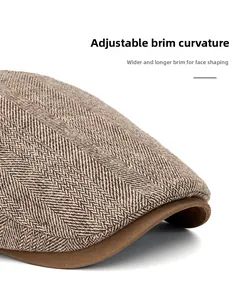 Detail of brown herringbone newsboy cap with wide foldable brim and wool-like texture