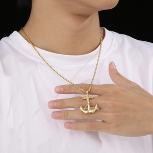 Detail of a vintage golden anchor pendant necklace on a model with a twisted chain