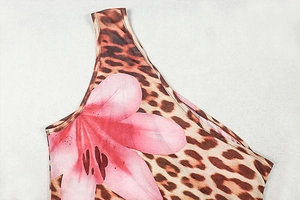 Dettaglio di gigli rosa e stampa leopardata con cuciture taglia-cuci di precisione