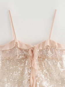 Detail of pink sequin camisole featuring ruffle trim and a delicate bow tie on the chest