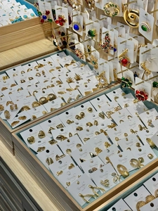 Detailed display of colorful enamel flower earrings arranged on branded display cards