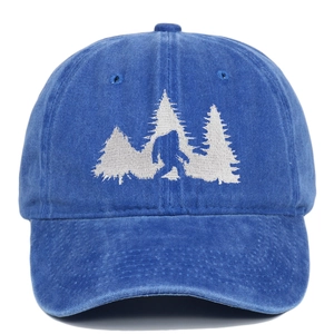 Detailed close-up of Bigfoot and pine forest embroidery on washed cotton baseball cap