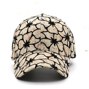 Detailed close-up of a floral print baseball cap with beige fabric and black flower patterns