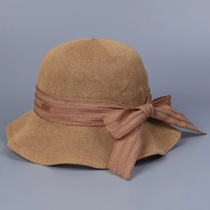 Detailed close-up of woven straw sun hat with elegant ribbon bow and textured wide brim