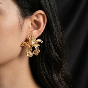 Statement gold irregular flower earrings with textured petals shown on model