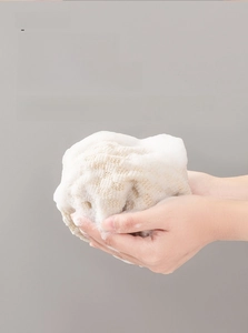Macro view of textured exfoliating back scrubber creating rich dense soap bubbles