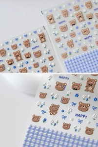 Detailed view of cartoon bear nail stickers with blue floral patterns and bow accents