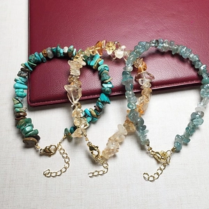 Detail of three crystal chip bracelets featuring turquoise and citrine with lobster clasp