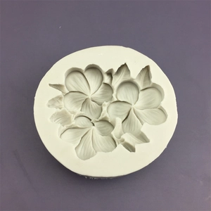 Macro shot of white silicone mold featuring detailed frangipani flower and leaf patterns