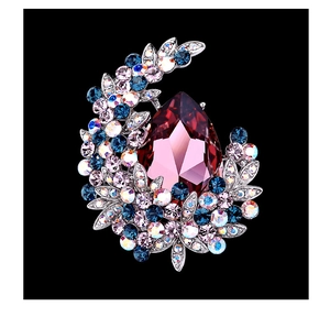 Macro shot of silver crescent brooch with drop-shaped purple stone and blue rhinestones