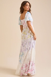 Détail de la robe à fleurs avec manches bouffantes, dos lacé et jupe plissée élégante