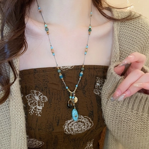 Dettaglio della collana boho con perline, pendente turchese e nappe etniche
