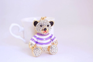 Macro shot of bear keychain with white rhinestones and purple striped shirt