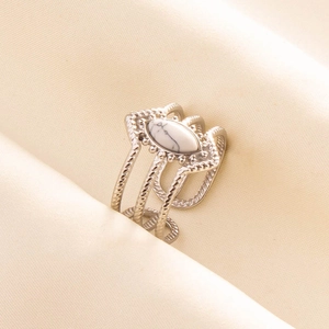 Close-up of vintage silver stainless steel ring with white marble stone on silk