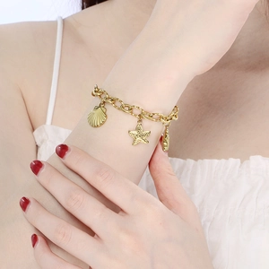 Détail du bracelet en acier inoxydable plaqué or 18k avec breloques étoile de mer et coquillage
