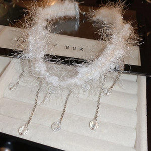 Detailed macro view of white plush choker with crystal fringe and silver metal chains