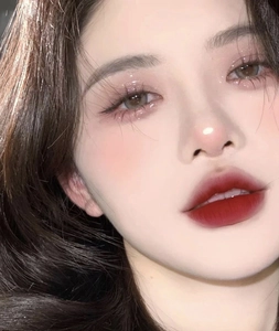 Dettaglio dell'ombretto rosa scintillante e del rossetto rosso scuro sul modello di trucco