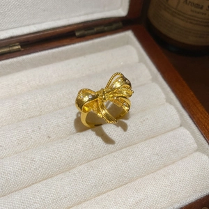 Detail shot of a 18k gold plated bow ring with sparkling zircons on velvet lining