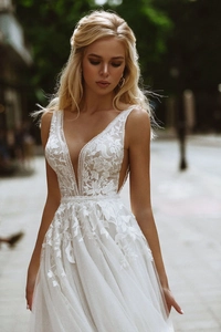 Detailed view of the deep V-neck wedding dress featuring floral lace and pearl waistband
