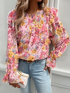 Detail of pink floral chiffon blouse with smocked chest and ruffled cuffs on model