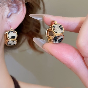 Primo piano di orecchini leopardati quadrati placcati oro 18K indossati dal modello