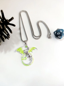 Detail view of a dragon pendant necklace with lime green luminous enamel on a silver chain