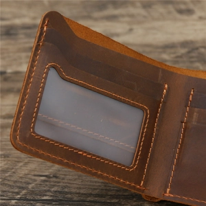 Vintage crazy horse leather wallet with internal card slots and ID window on wood